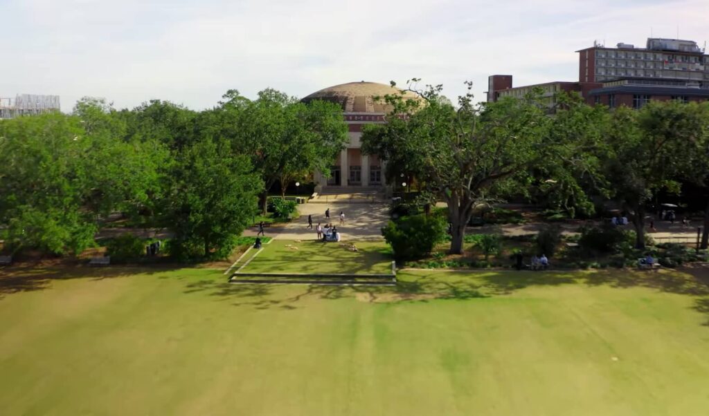 An aerial view of a large campus quad in front of a domed building