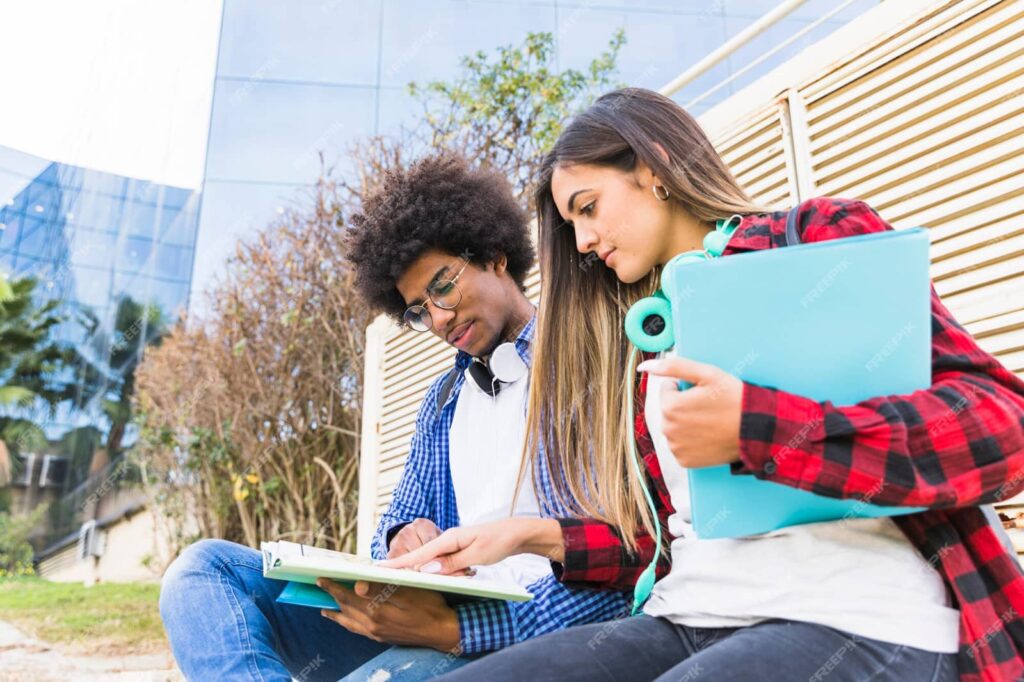 Students studying together in front of the university building